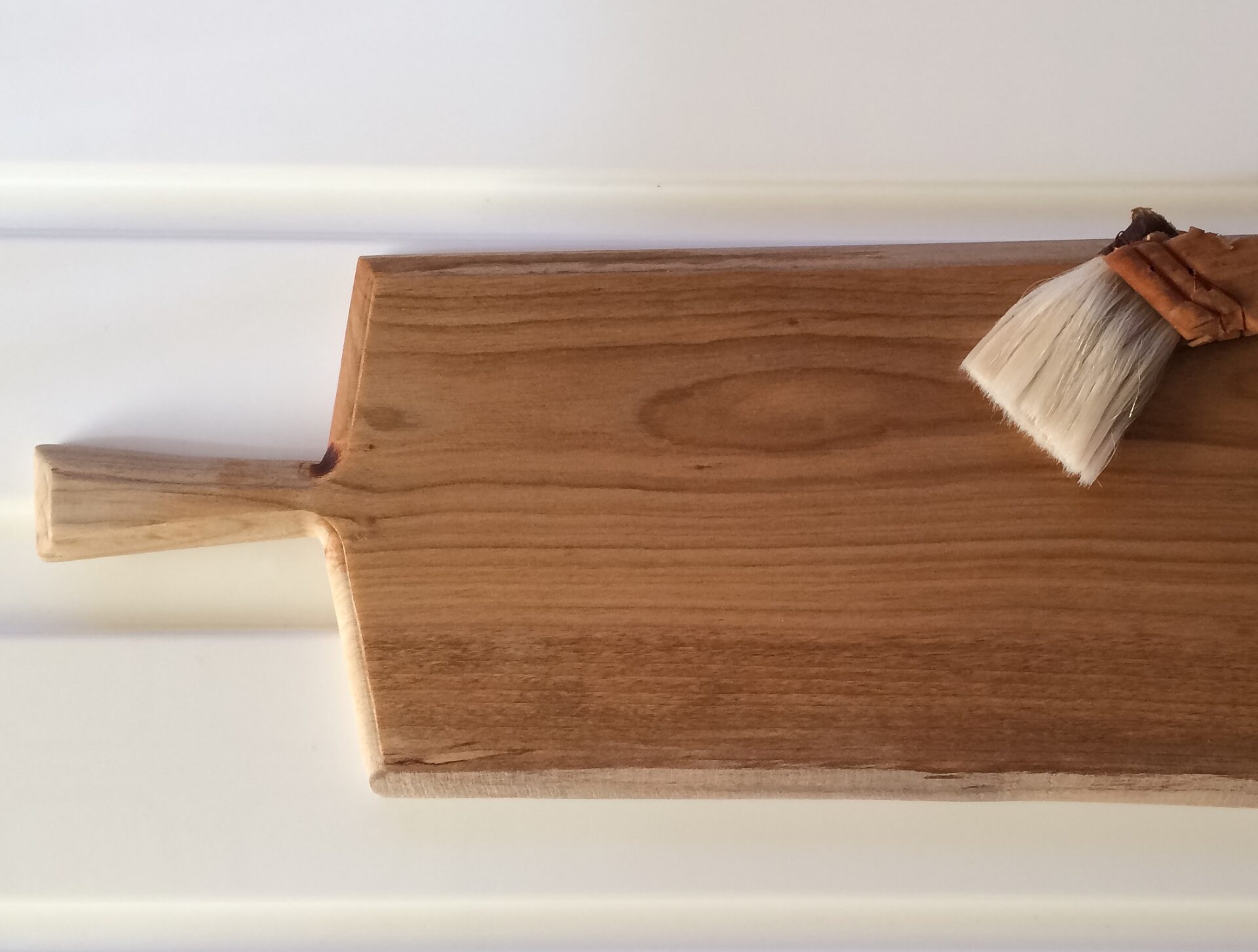 カッティングボードに木製食器用オイルを塗布している様子