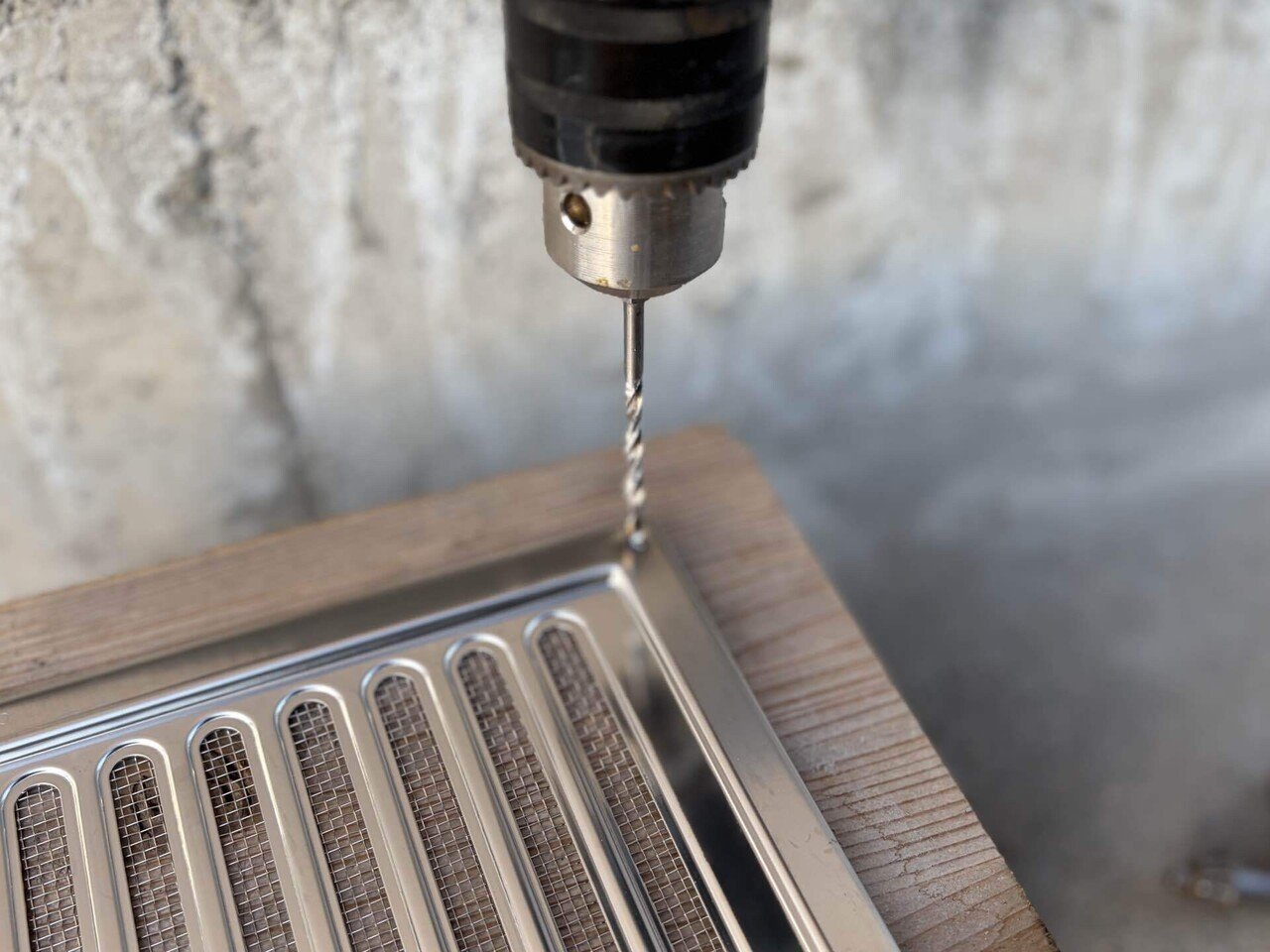 電動ドリルでステンレス製通気口に穴あけ