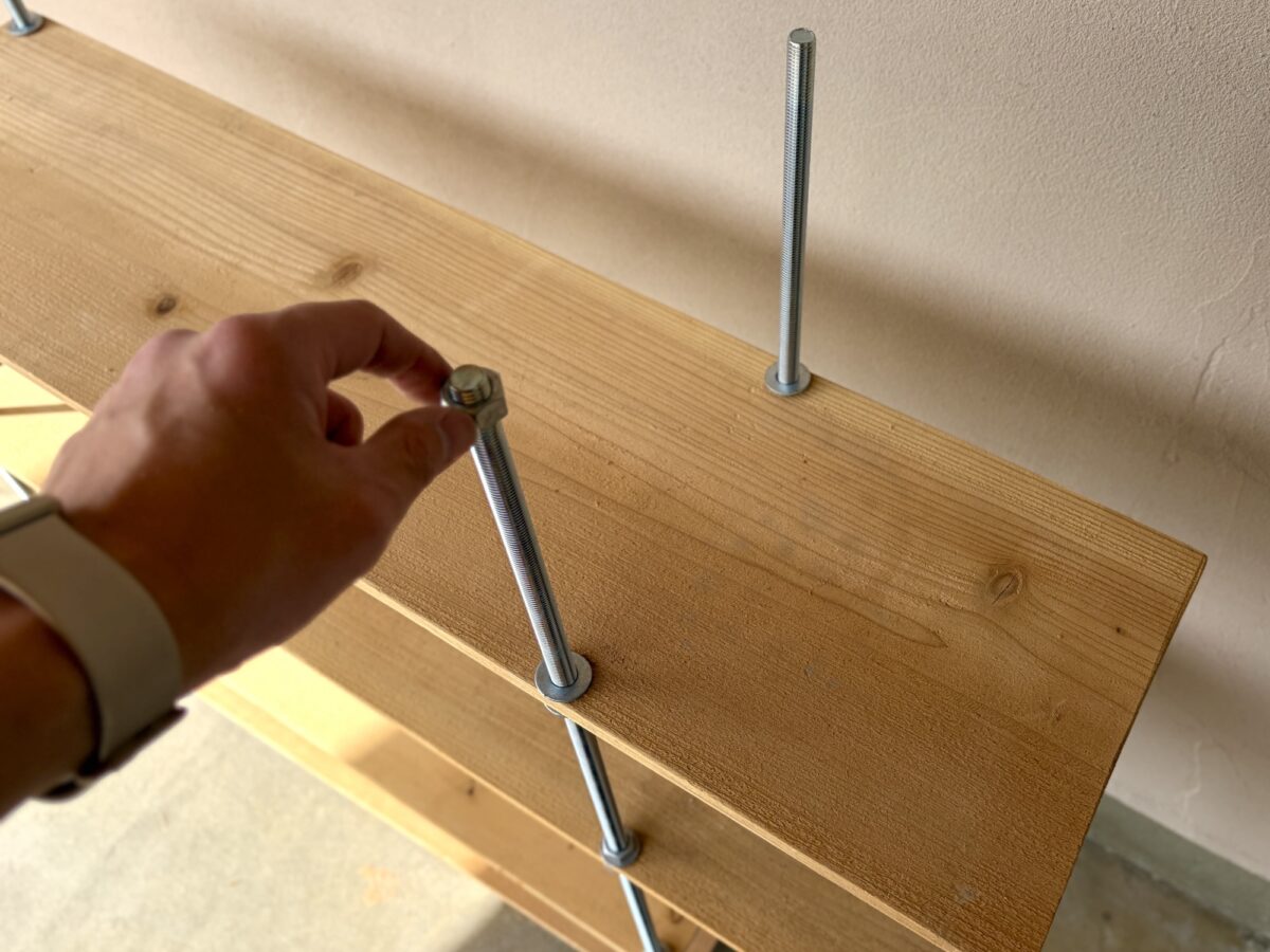 寸切ボルトにワッシャー、ナットの順で取り付けていく様子