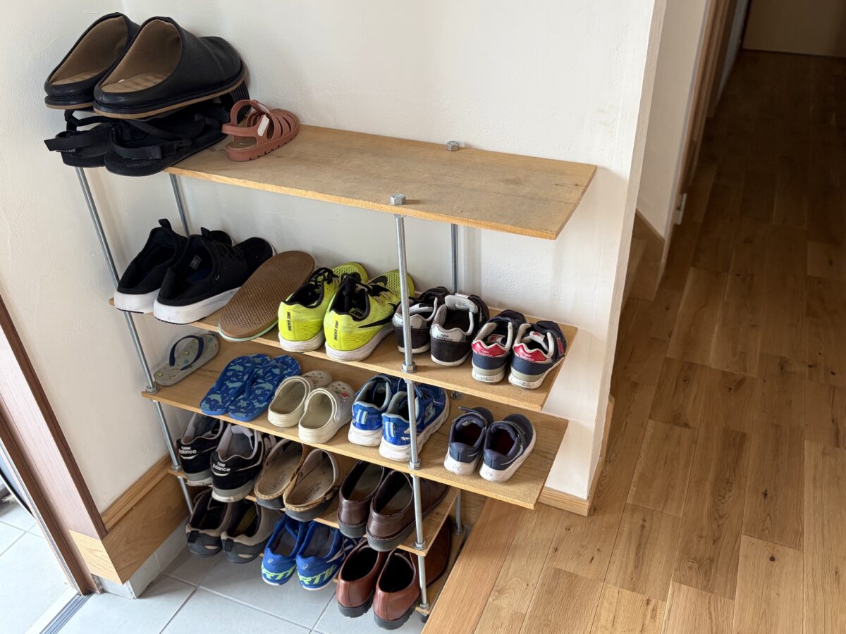 寸切ボルトと杉板でDIYしたシューズラックに家族の靴が並んでいる様子